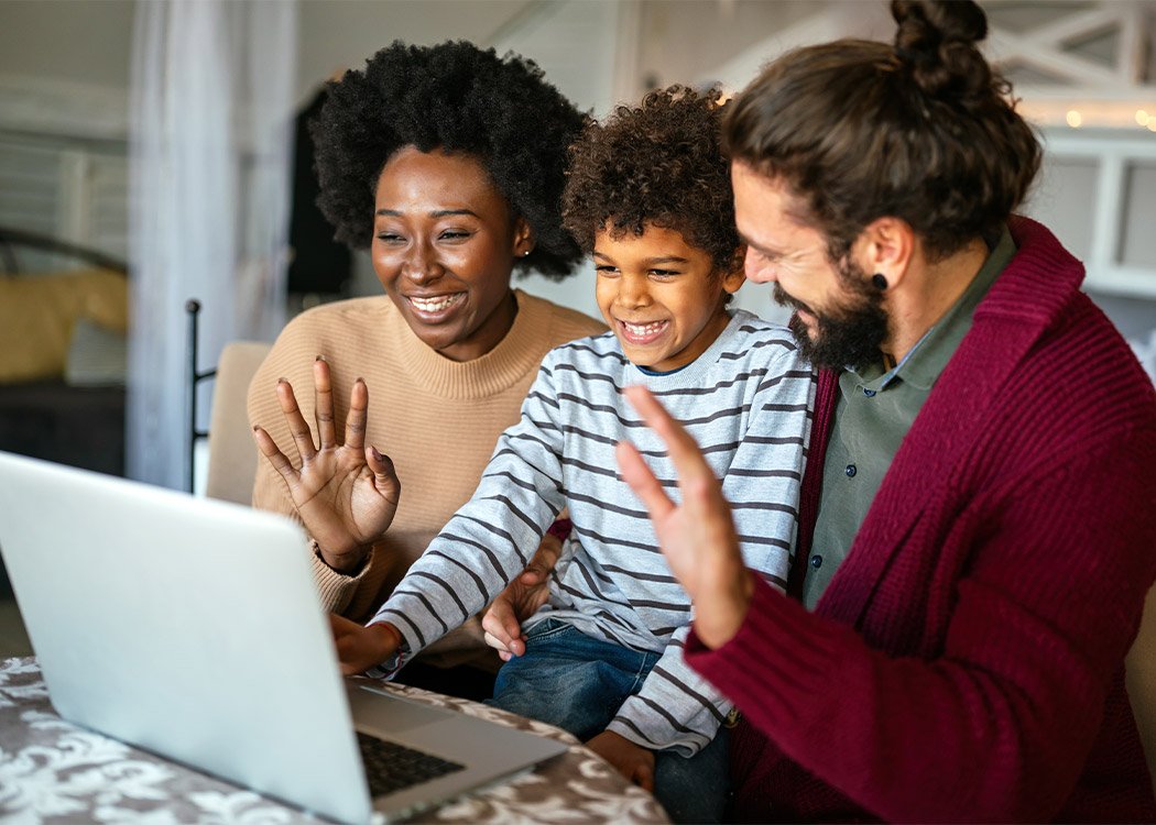 Smiling family calling on computer at home.