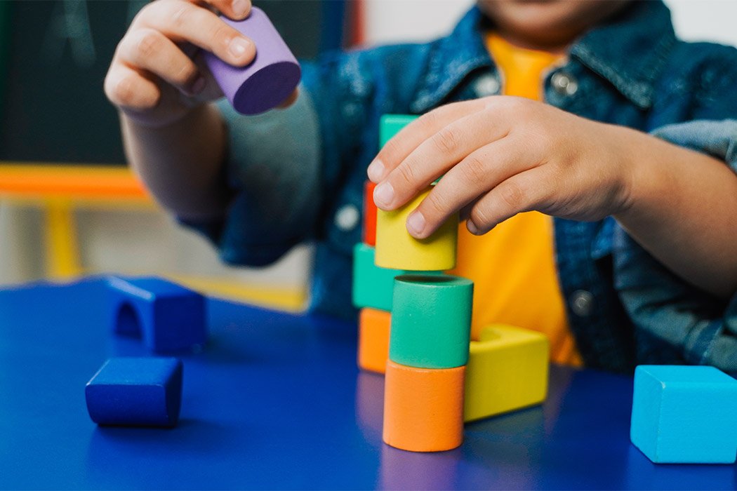 Kid hands playing with wood toys.