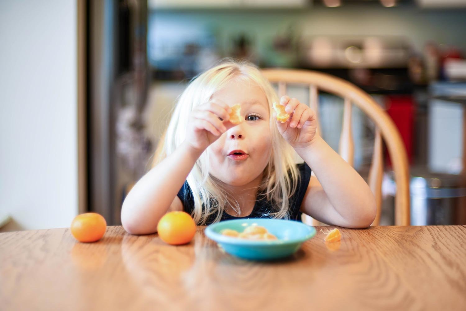 Child playing with their food at a table.