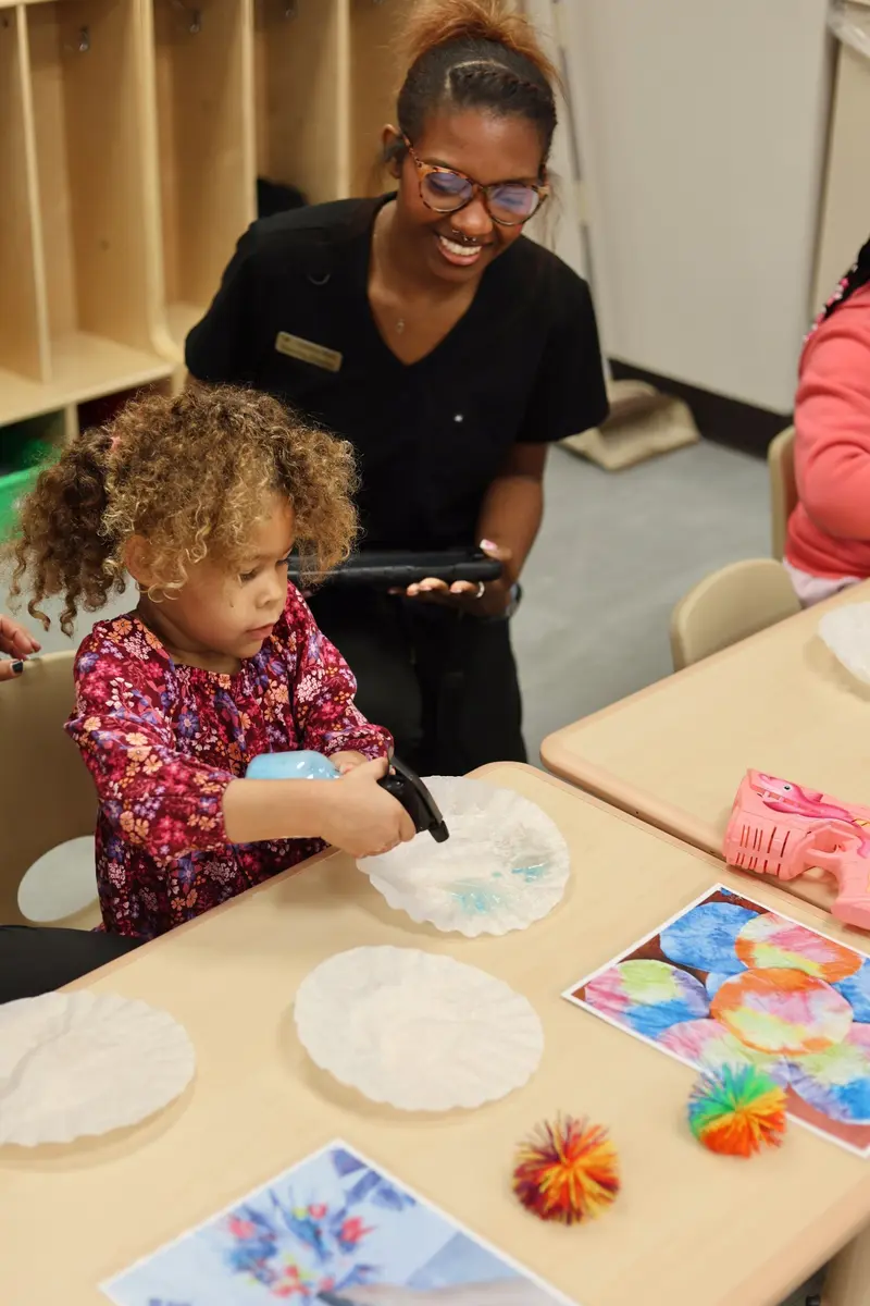 Child completing a hands-on activity with an AB Spectrum team member
