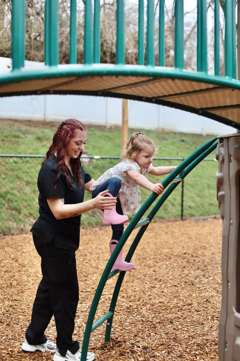 AB Spectrum team member supporting a child on a playground
